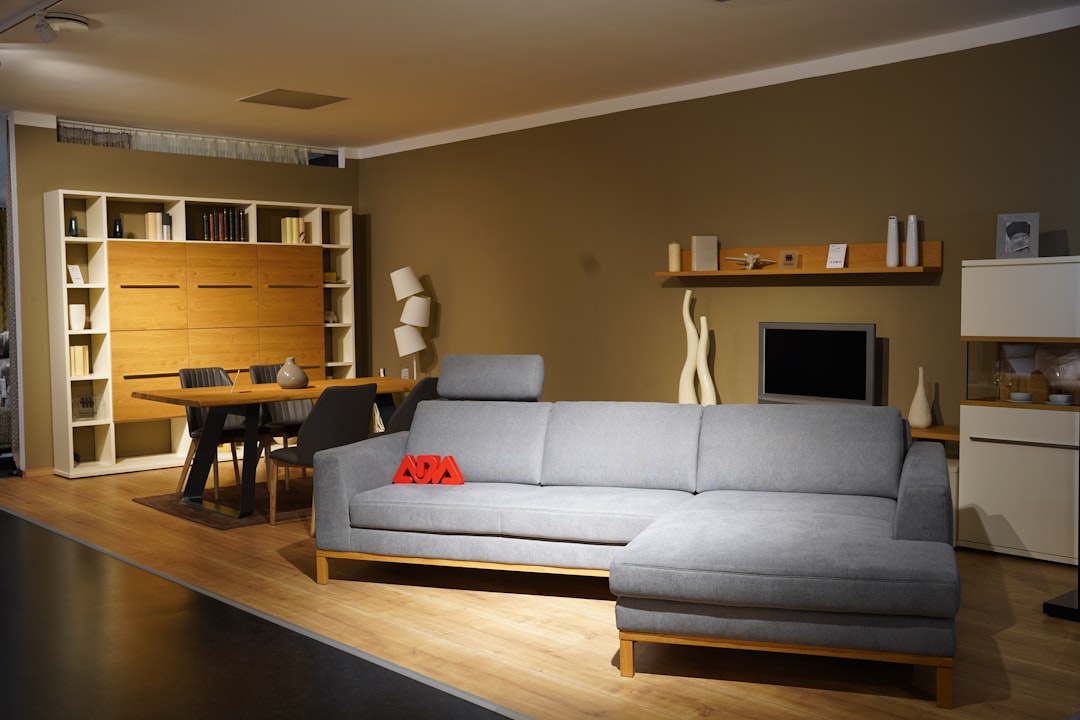 Modern living room with gray sectional sofa, wooden furniture, and stylish minimalist decor.